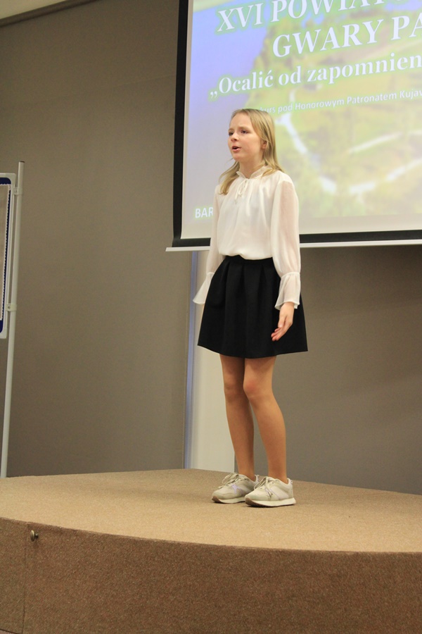 uczestniczka konkursu recytuje wiersz przed jury i publicznością