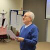 Pan Mirosław Binkowski stoi przed zebranymi uczestnikami i widownią, odczytuje wyniki konkursu