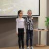 2 uczestników z pierwszej kategorii wiekowej stoi na scenie i występuje przed publicznością