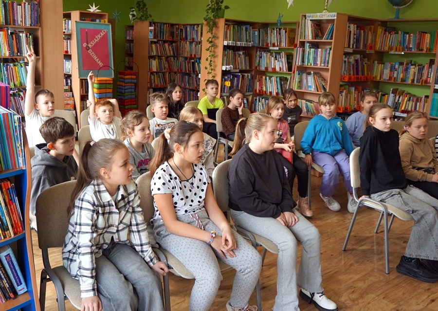 Dzieci siedzą na krzesłach w trakcie spotkania