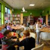dzieci pracujące na zajęciach siedzące przy prostokątnych stołach