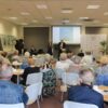 Sala wypełniona publicznością, przed którą występuje zespół.
