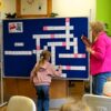 Dziewczynka biorąca udział w spotkaniu wpisuje hasło do krzyżówki