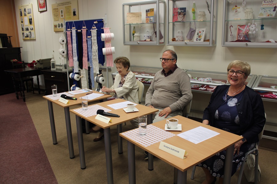 jury konkursu, dwie kobiety i mężczyzna siedzący przy kwadratowych stolikach