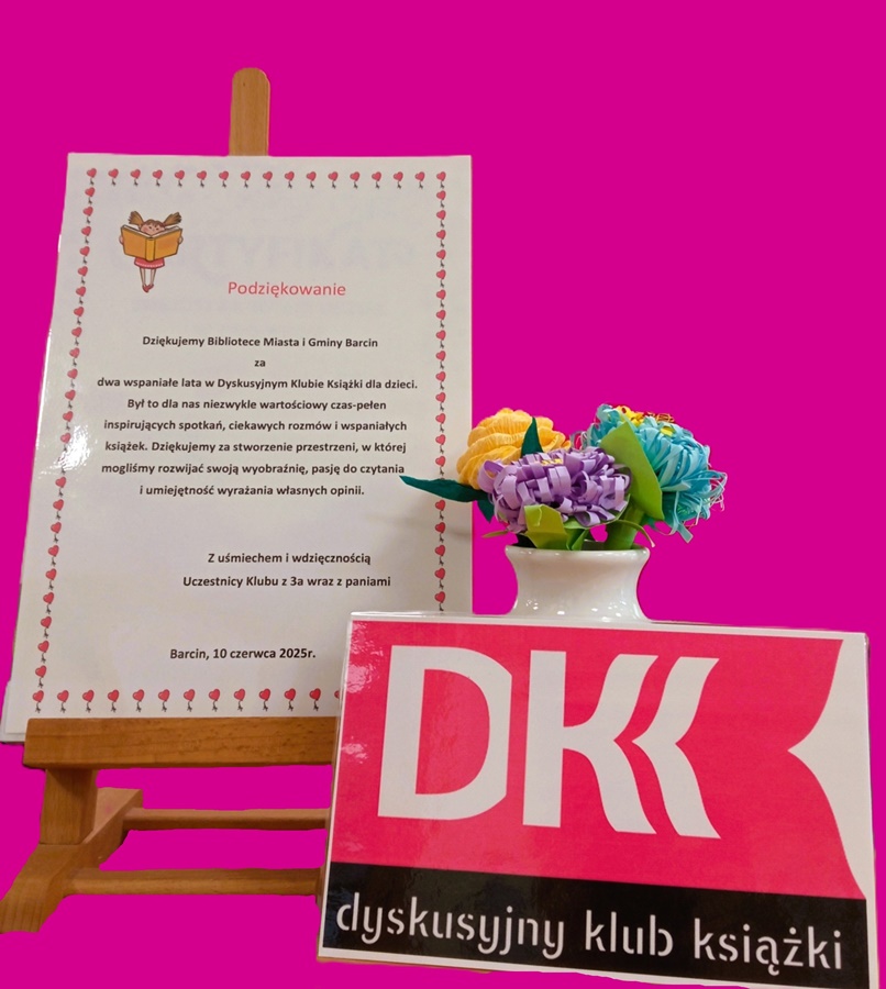 podziękowani na sztaludze, obok wazonik z kwiatami przed nim logo dkk wydrukowane i zalaminowane