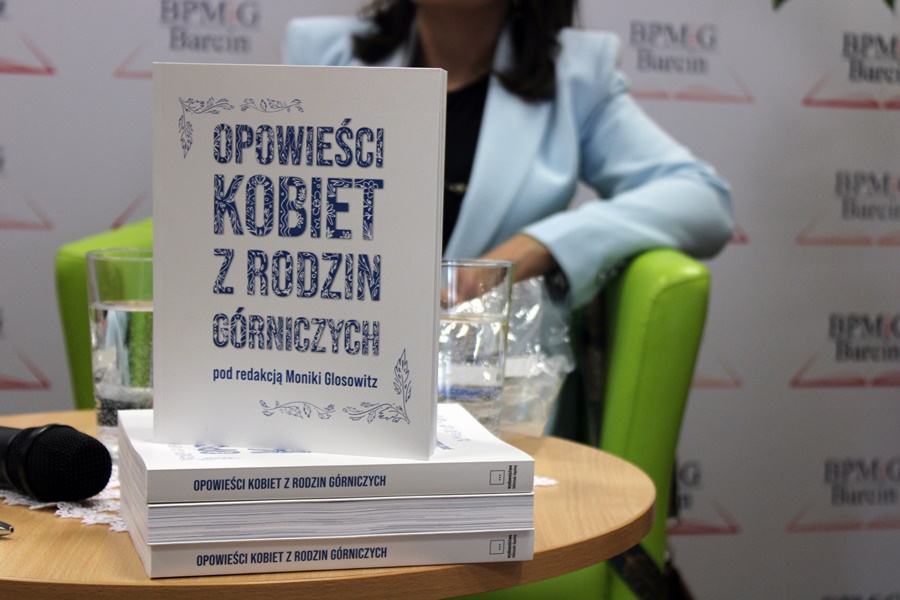 ksiażka "Opowieści kobiet z rodzin górniczych" stojąca pionowa na innych egzemplarzach, białe tło niebieski napis
