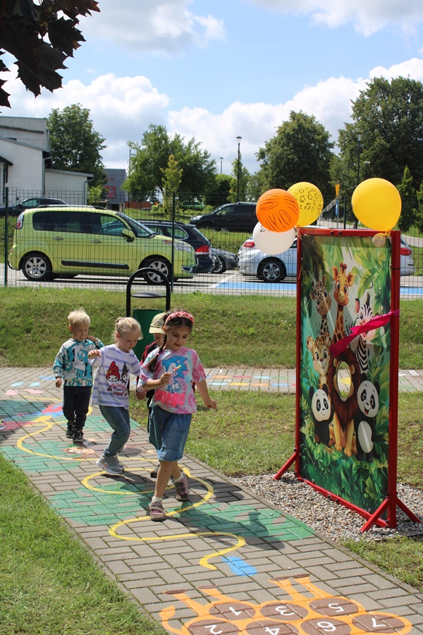 dzieci idące kolorową ścieżką, korzystają z przygotowanej atrakcji