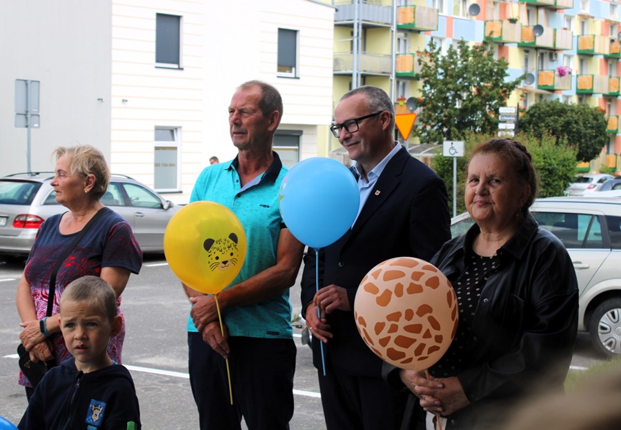 Dwóch mężczyzn i jedna kobieta stoją obok siebie i w rękach trzymają balony na patyku