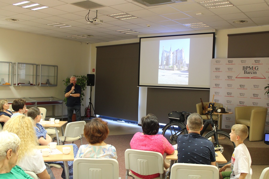 Zaproszony gość w trakcie spotkania opowiada o wyświetlanych przez projektor zdjęciach