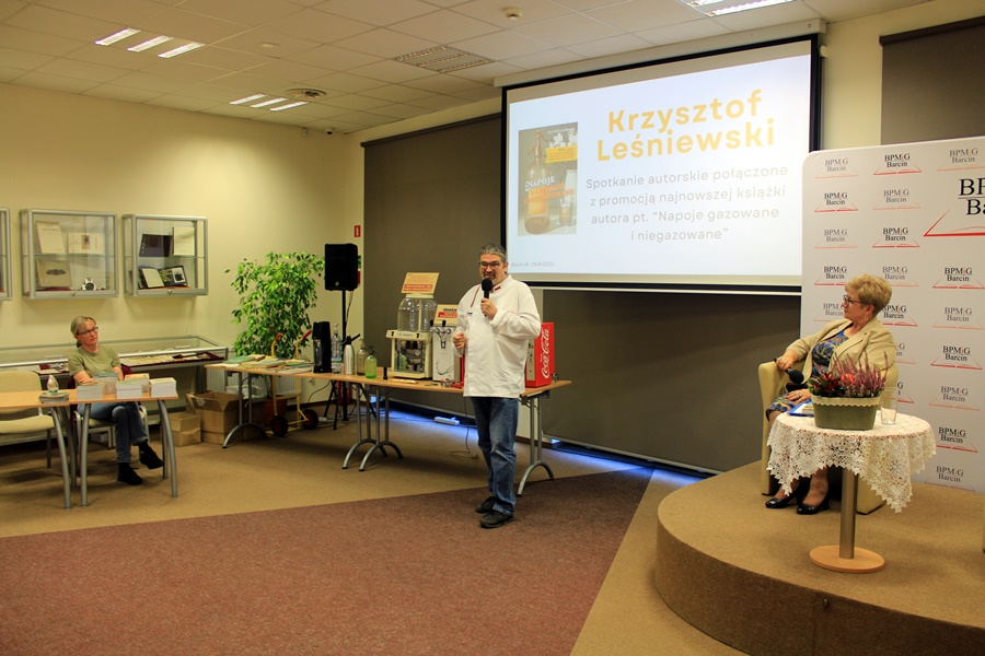 Pan Krzysztof stoi obok przywiezionych eksponatów i mówi coś do publiczności