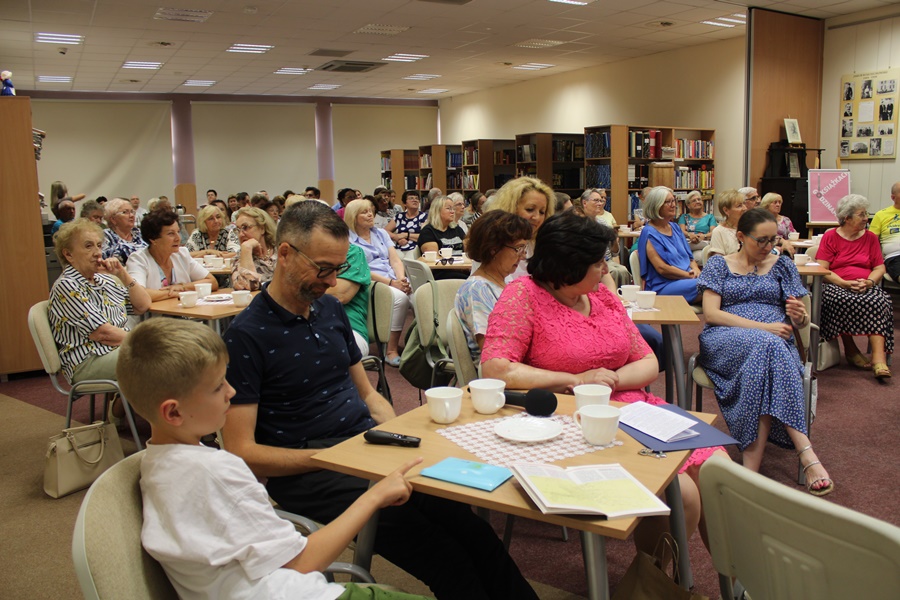 publiczność siedząca przy stolikach z uwagą słucha opowieści o podróży do Santiago