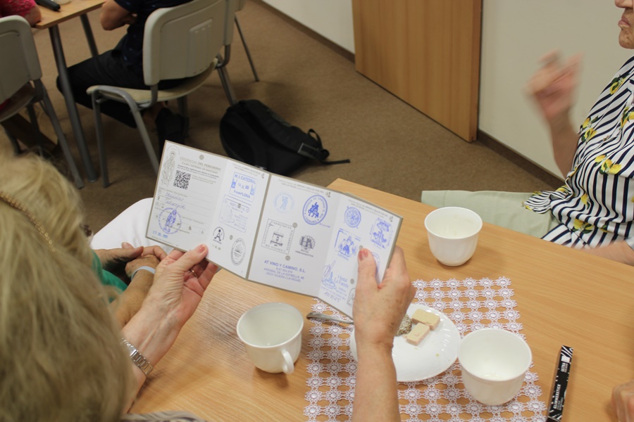 osoba z publiczności ogląda paszport pielgrzyma przywieziony przez zaproszonego gościa