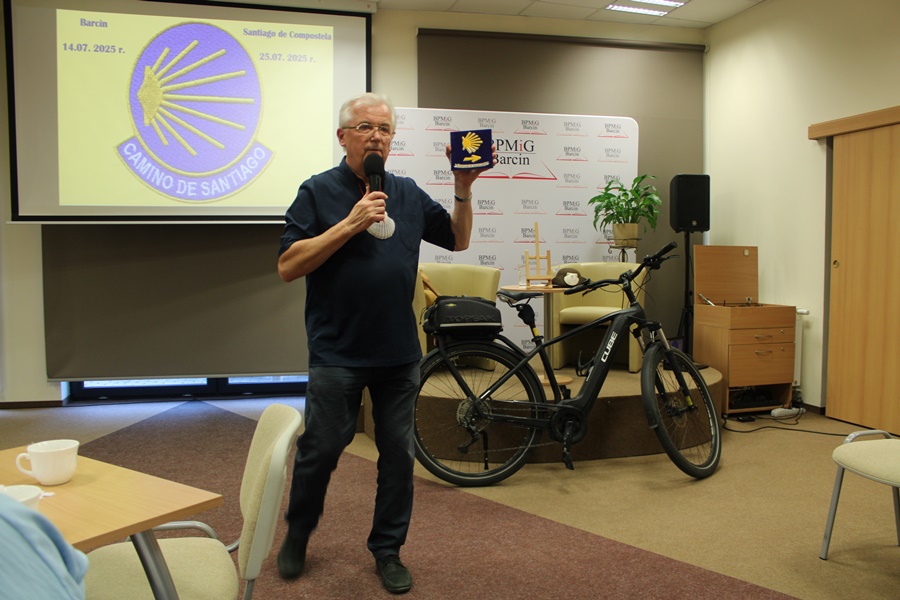 Zaproszony gość prezentuje publiczności symbol oznaczający przemierzany szlak