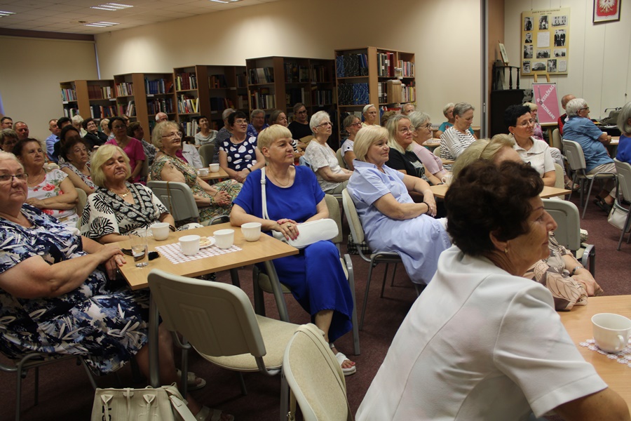 Liczna publiczność zgromadzona w sali z uwagą słucha opowieści o pielgrzymce