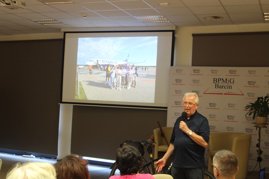 Zaproszony gość w trakcie spotkania opowiada o wyświetlanych przez projektor zdjęciach