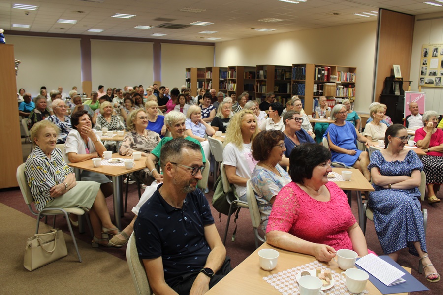 Liczna publiczność zgromadzona w sali z uwagą słucha opowieści o pielgrzymce
