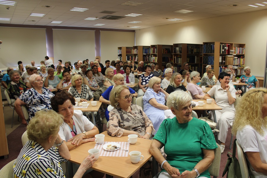 Liczna publiczność zgromadzona w sali z uwagą słucha opowieści o pielgrzymce