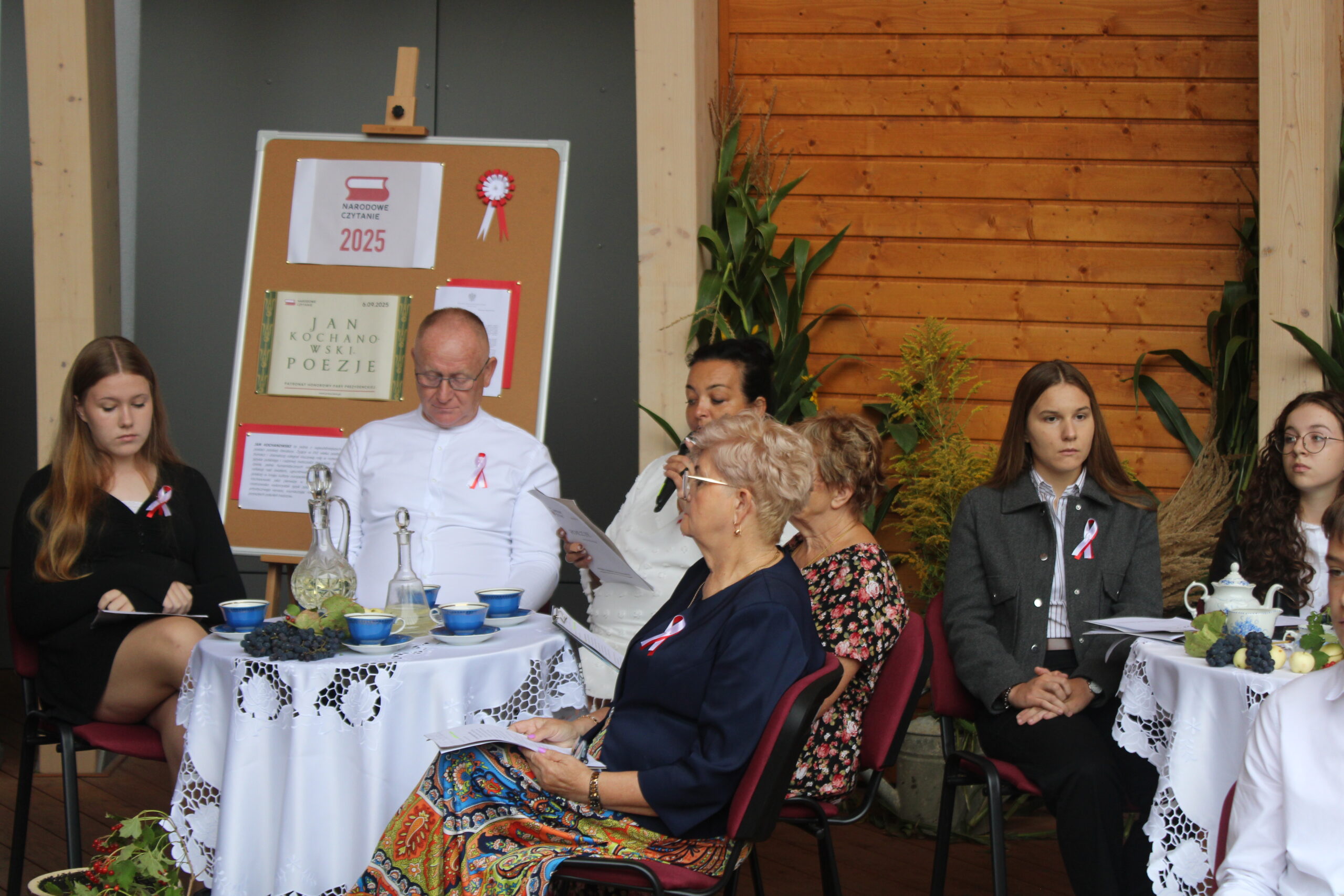 grupa osób występujących w wydarzeniu siedzi i czeka na swoją kolej