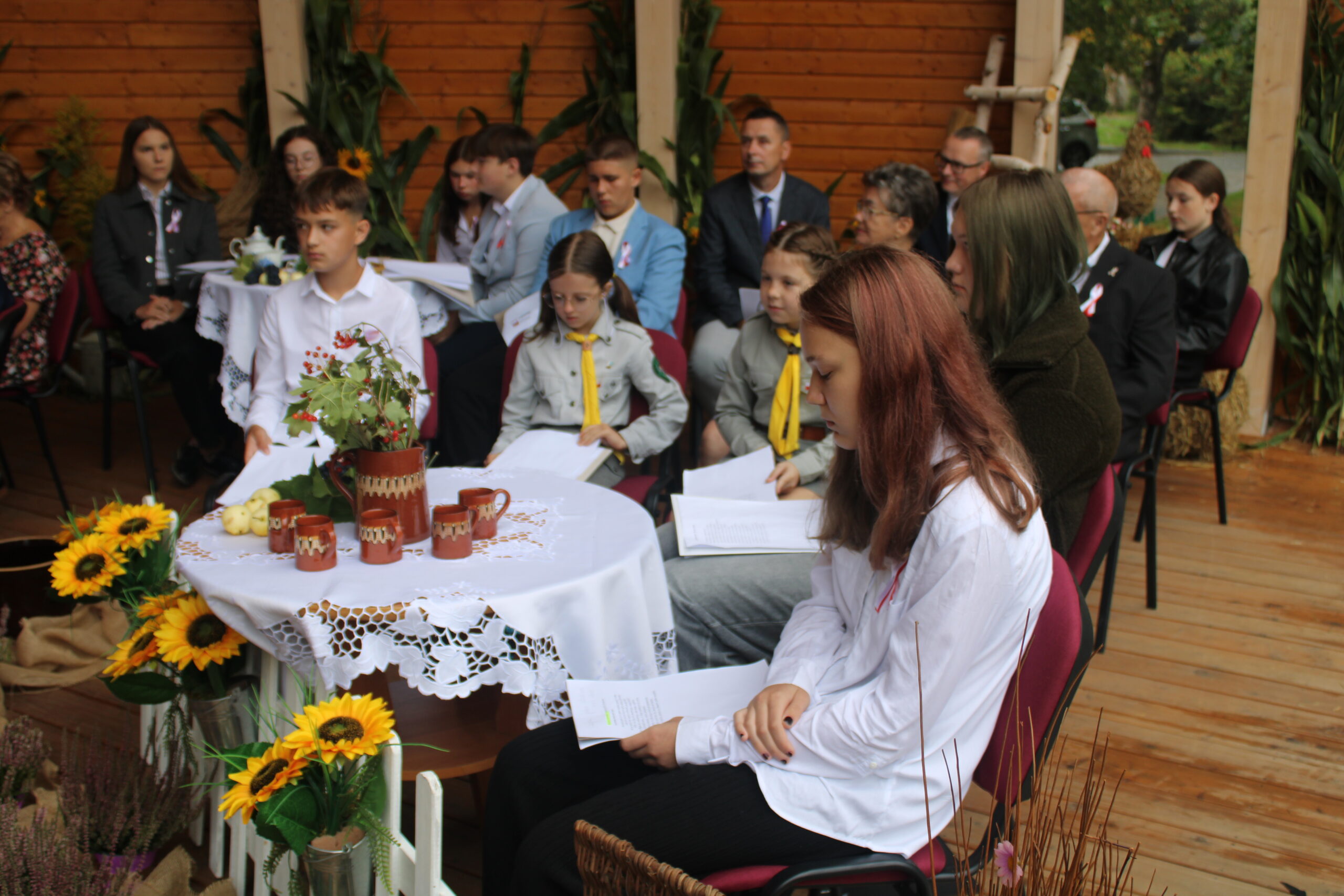 grupa osób występujących w wydarzeniu siedzi i czeka na swoją kolej
