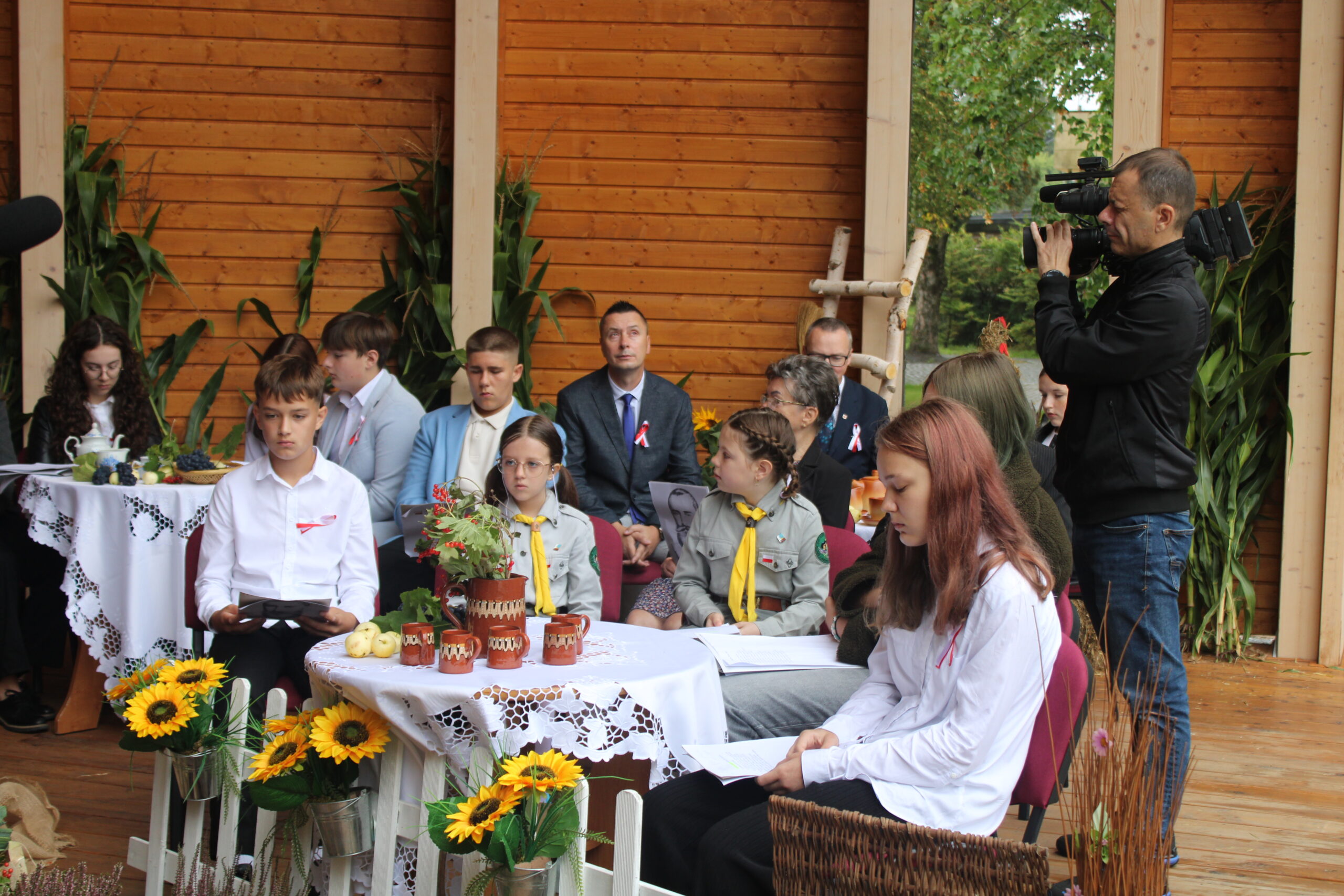 grupa osób występujących w wydarzeniu siedzi i czeka na swoją kolej
