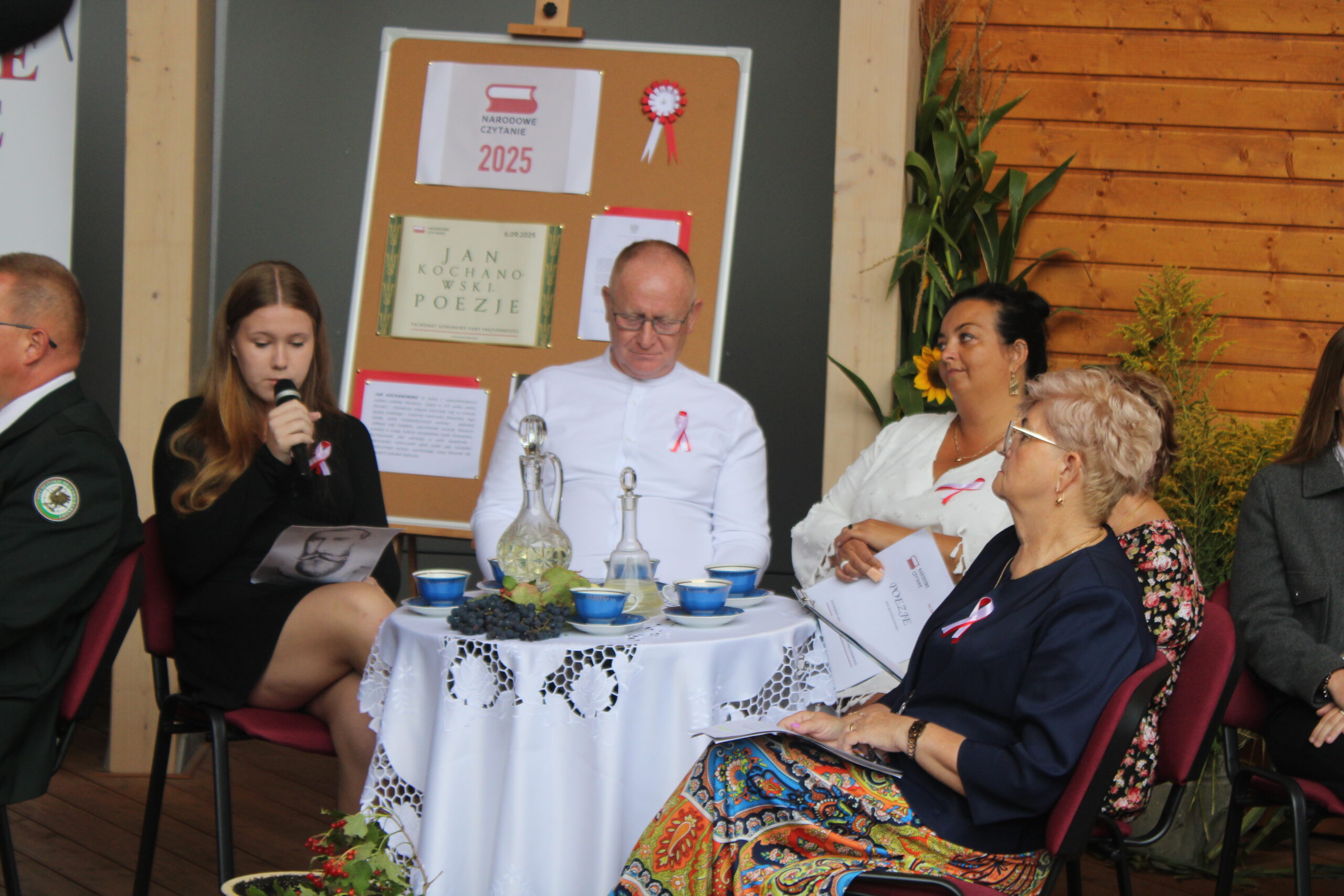 osoby siedzące przy stoliku słuchają prowadzących