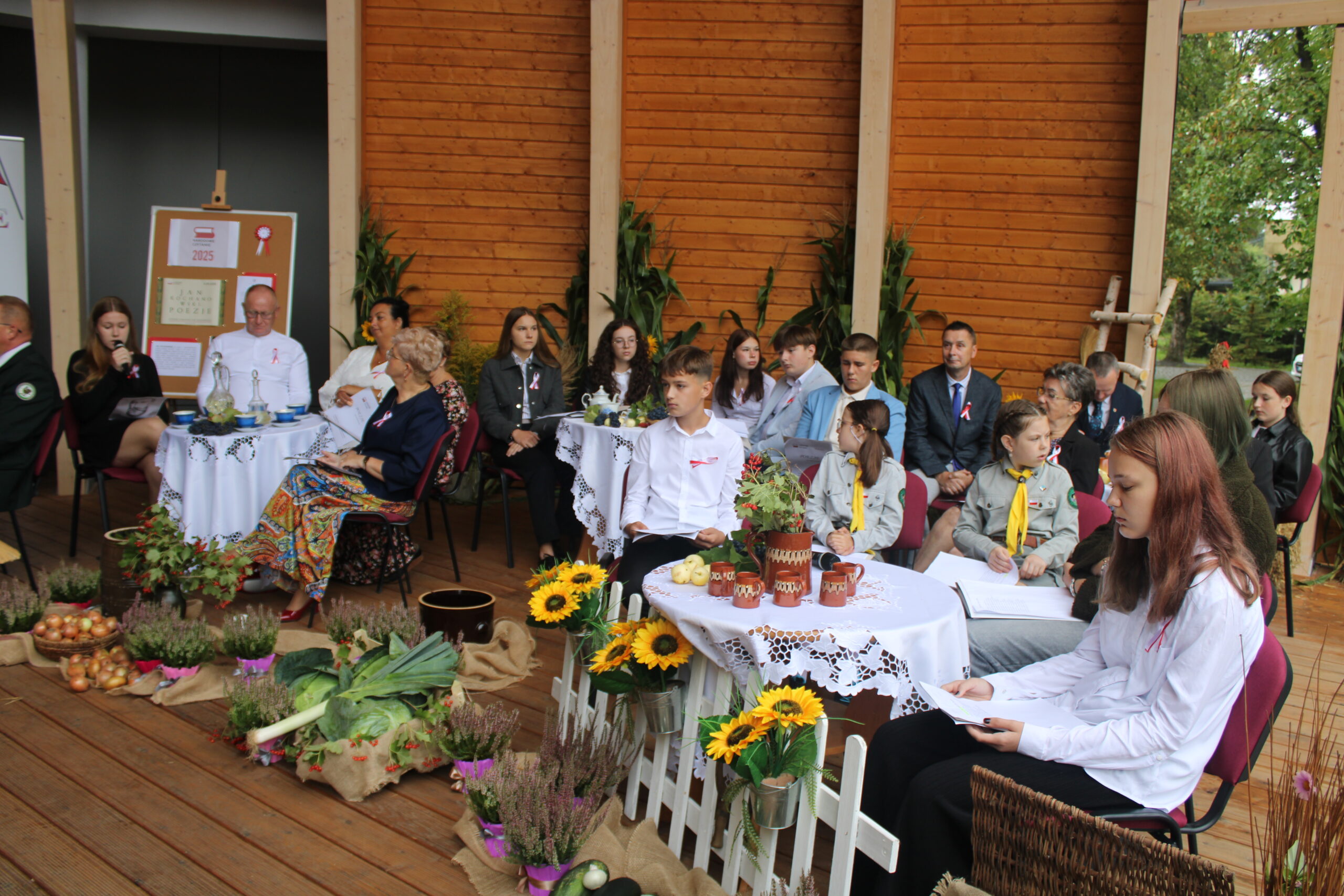 grupa osób występujących w wydarzeniu siedzi i czeka na swoją kolej