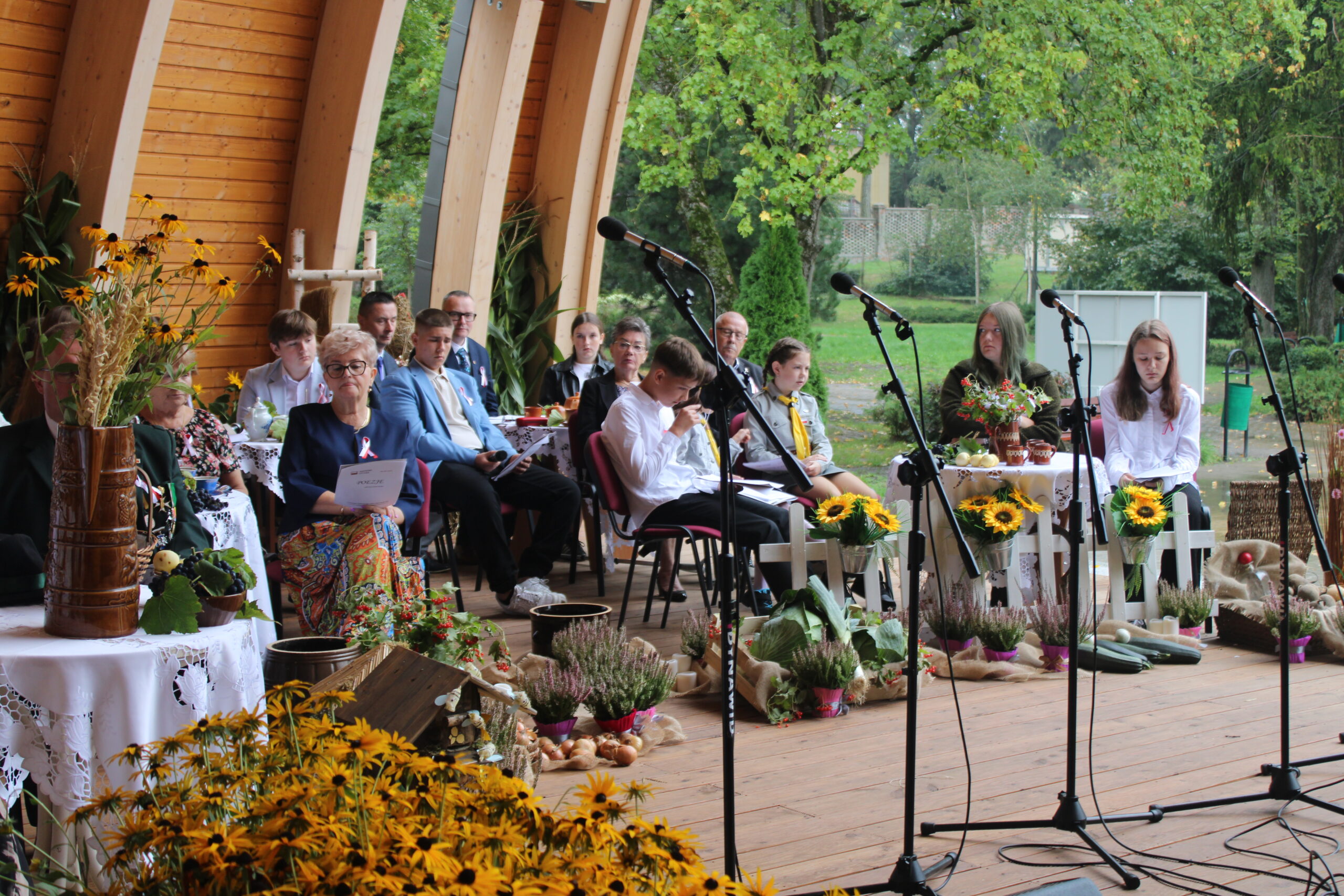 grupa osób występujących w wydarzeniu siedzi i czeka na swoją kolej