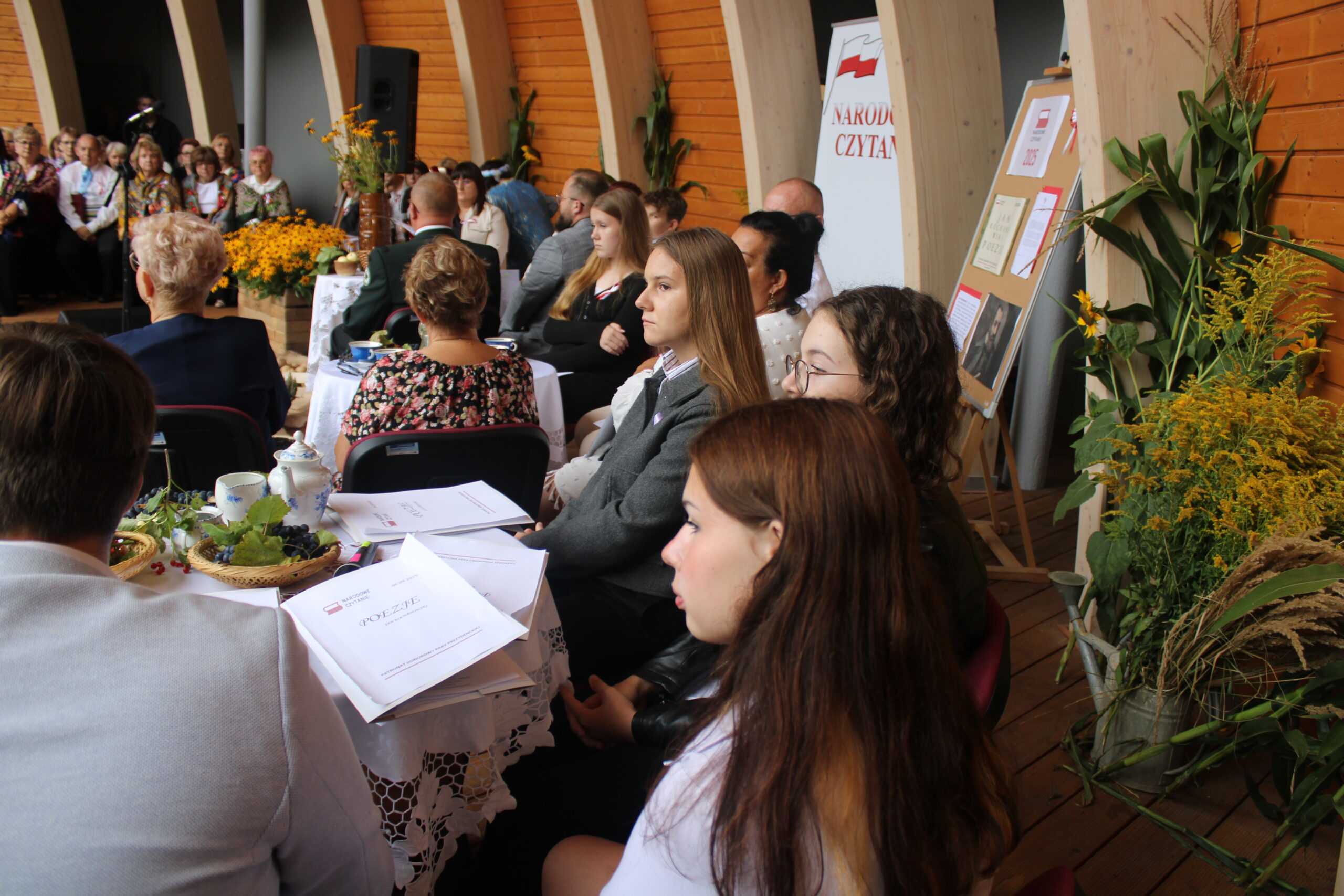 grupa osób występujących w wydarzeniu siedzi i czeka na swoją kolej