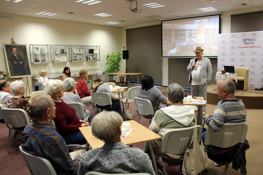 Zebrana publiczność słucha prelegenta i jego opowieści z podróży