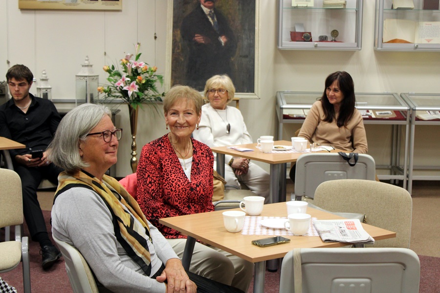 Zebrana publiczność słucha prelegenta i jego opowieści z podróży