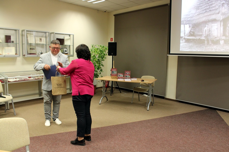 dyrektorka biblioteki wręcza podziękowania i upominek zaproszonemu gościowi