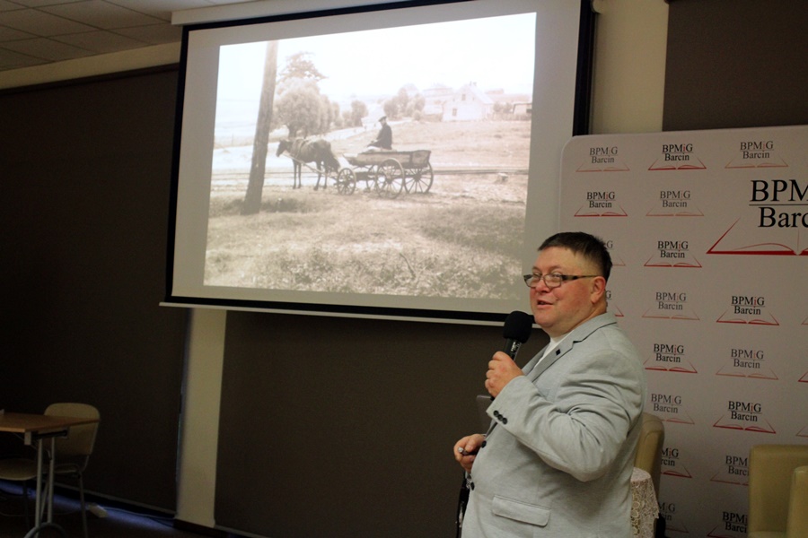 Zaproszony gość stoi z mikrofonem w ręce przed widownią