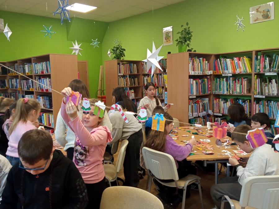 Część dzieci klei klejem kolorowe ozdoby inen dzieci zaczepiają gotowe ozdoby na sznurku