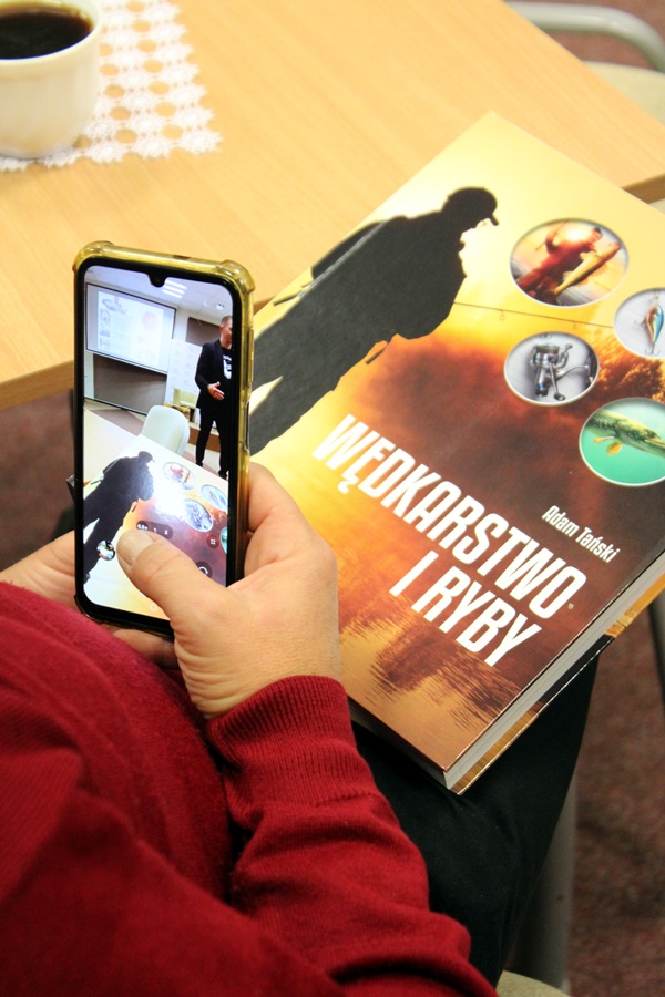 Książka przywieziona przez zaproszonego gościa trzymana przez jedną z osób z widowni