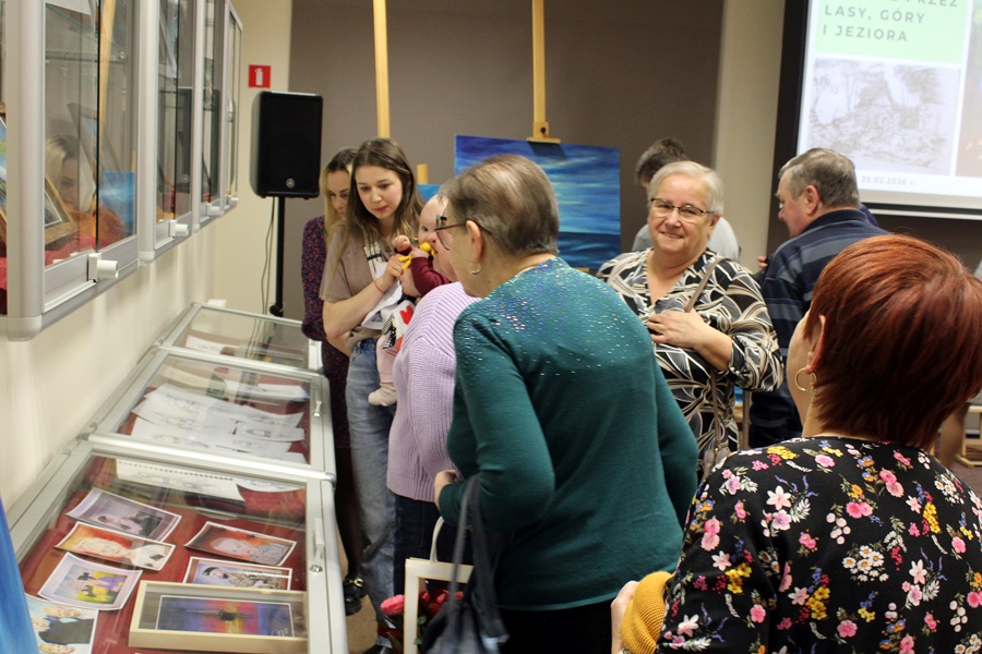 Osoby obecne na spotkaniu oglądają namalowane przez artystkę obrazy