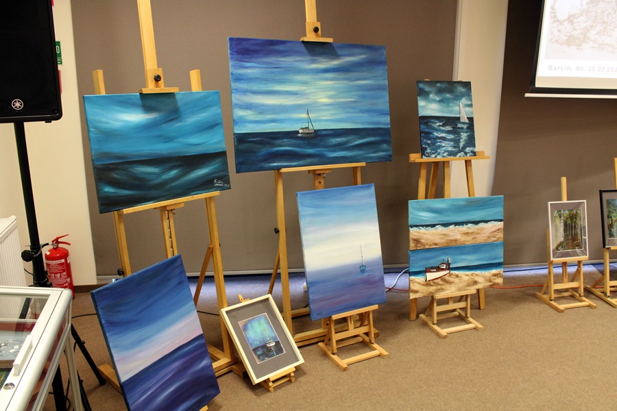Prace artystki przedstawiające krajobrazy związane z morzem i łodziami, przeważa na nich kolor niebieski