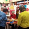Trzy kobiety przyglądają się innej kobiecie która wykonuje pisankę