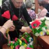 Kobieta układa kompozycje kwiatową w wazonie