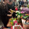Obecni na wydarzeniu ludzie oglądają wystawę ustawioną w bibliotece
