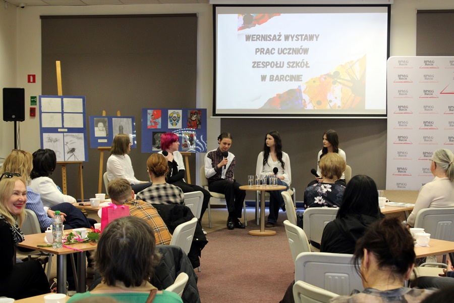 Zaproszeni artyści siedzą przed publicznością i opowiadają o swojej pasji.