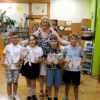 Bibliotekarka i czwórka dzieci na wspólnym zdjęciu, dzieci trzymają otrzymane dyplomy